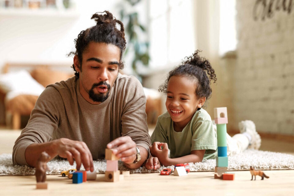 Parent et enfant jouant ensemble sur le sol du salon