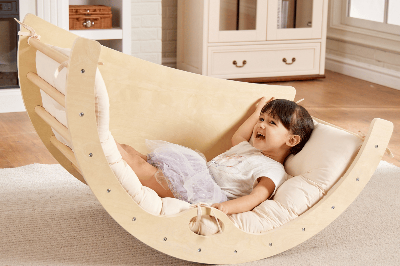 Enfant qui se balance sur l'arche Montessori convertible en balancelle
