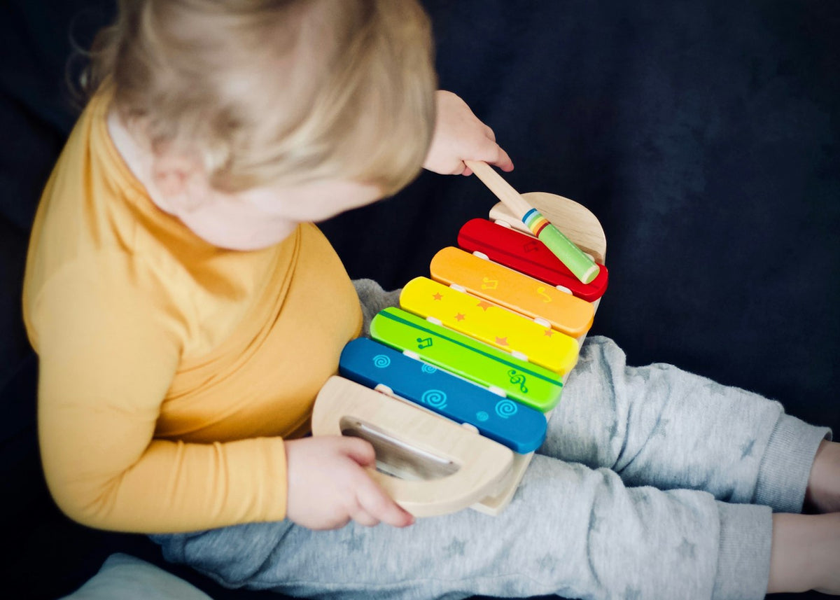 Enfant de 18 mois jouant avec un xylophone en bois