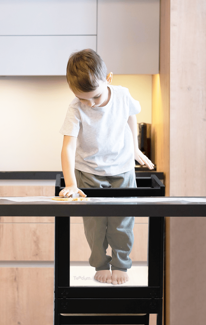 Enfant qui cuisine sur une tour montessori